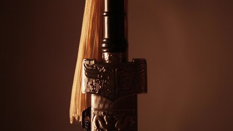 A woman's hand takes a sword out of the sheath, close-up