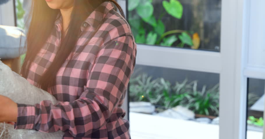 Smiling couple unpacking boxes in new house 4k