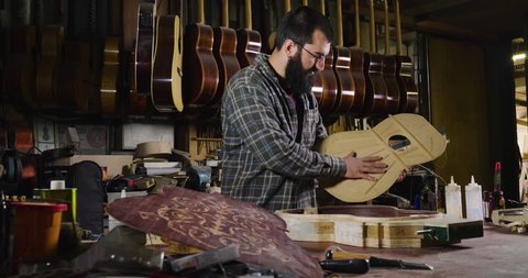 In his laboratory, a liutist builds high quality guitars for musicians, working fine wood. Concept of: music, tradition, ancient crafts.