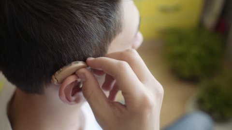 the young man wears a hearing aid. Man with hearing aid