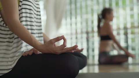 Female hands during yoga meditation in lotus pose in studio rapid slow motion