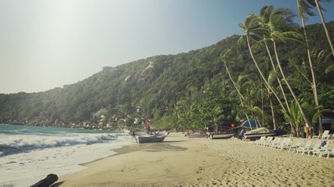 Moving Shot on a Idyllic Beach with Waves and Sea, Boats on Shore and in the Background Hills with Green Jungles. Shot on RED Epic 4K UHD Camera.
