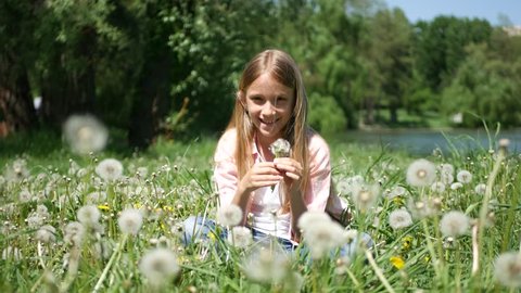 Child Playing in Park, Girl Blowing Dandelion Flowers on Meadow Outdoor Nature