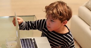 Child starring at computer screen. candid real life authentic clip of kid watching content online