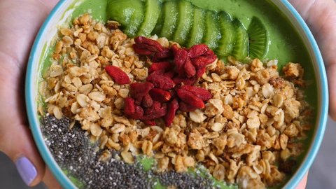 Closeup Of Vegan Avocado Green Smoothie Bowl Topped With Granola, Chia And Goji