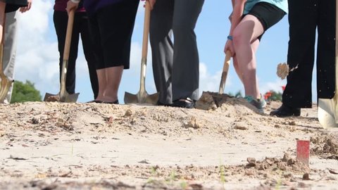 Groundbreaking shovels throwing dirt celebrate new business corporate franchising construction