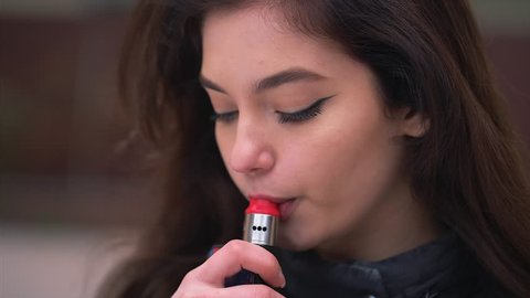 Pretty young girl model using vaporizer ecig gadget to quit smoking nicotine cigarettes.Popular ecig vaping device to vape glycerin ejuice. Girl smokes Vape