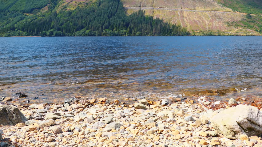 Pebble shore of a mountain lake. Scotland.