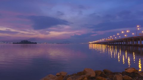 Time Lapse of Penang Bridge at sunrise with dramatic cloudy sky. Penang, Malaysia.
