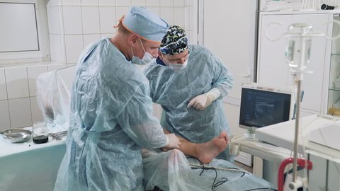 Phlebologists do the operation on the veins. The patient with varicose veins came to the operation. Doctors do ultrasound on the operating table. Specialists do work to remove varicose veins on their