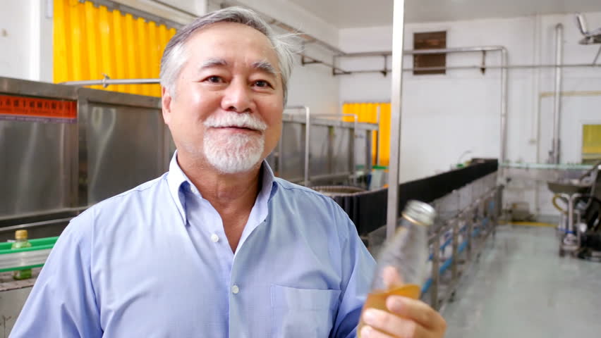 Senior Businessman show product at the factory floor. People working concept. 