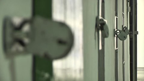 Close up rack focus across a large padlocks on prison cell or mental asylum facility doors