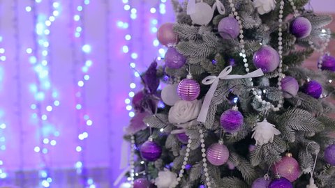 Christmas tree with purple and white balloons, flashing lights. Close-up. New year. Background. Bokeh. Christmas tree and Christmas decorations. Decorated Christmas tree on lights background.