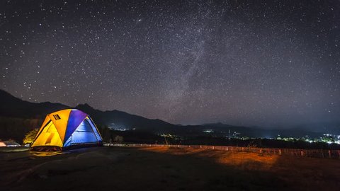 Time laps of milky way and stars of night clear sky above mountain with camping tent located north east of Thailand at Maehongsorn province. 