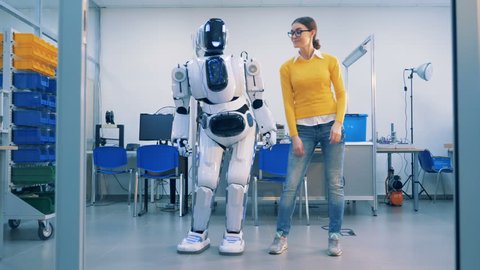 Young woman is dancing with a robot who spanks her playfully after whereafter she leaves