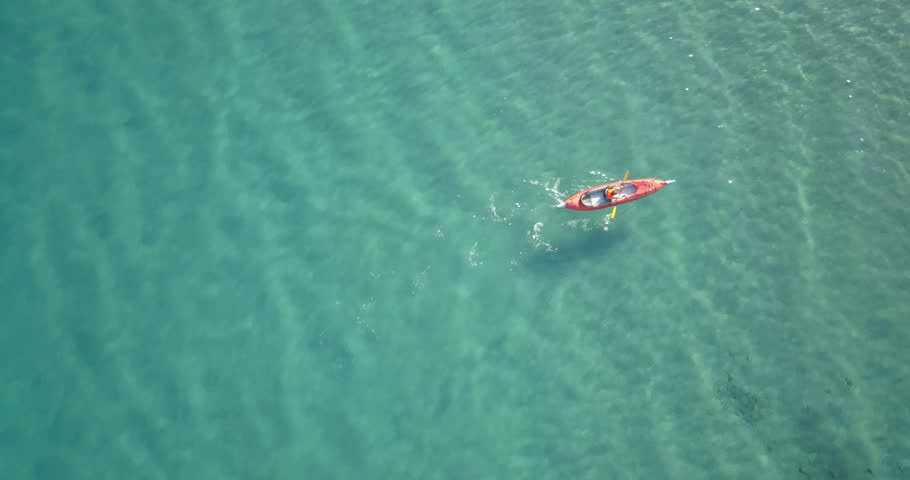 kid on canoe drone view in blue clear sea