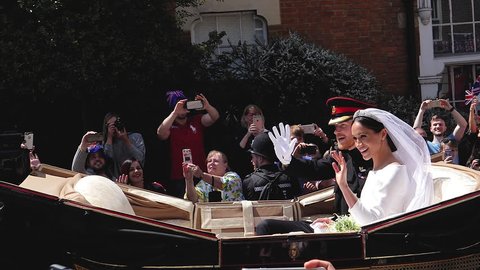 WINDSOR, ENGLAND - MAY 19 2018: Slow motion cinematic of Prince Harry and Meghan Markle wave hands ride in Ascot Landau after wedding ceremony St. George's Chapel in Windsor Castle ProRes 4444