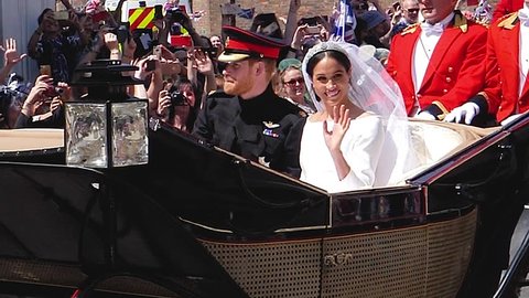 WINDSOR, ENGLAND - MAY 19 2018: Slow motion footage of Prince Harry and Meghan Markle wave hands ride in Ascot Landau after their wedding ceremony at St. George's Chapel in Windsor Castle ProRes 4444