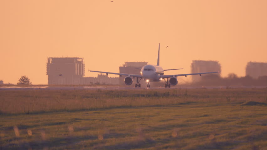 Airplane taking off at sunset. Aircraft takes off at dawn. Long shot  Royalty-Free Stock Footage #1011390542