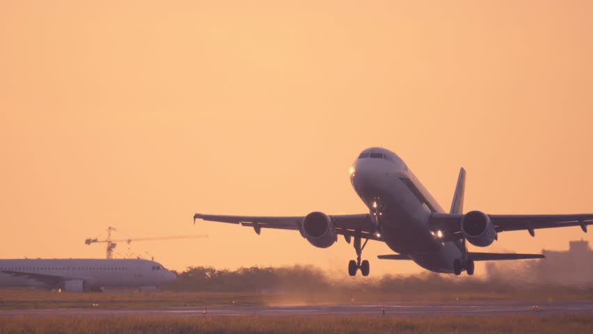 Airplane taking off at sunset. Aircraft takes off at dawn. Long shot 