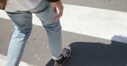 Young man walking on zebra crossing on the street