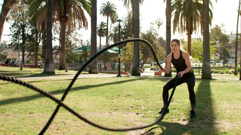 Very athlete woman works out in the park. Slow motion.
