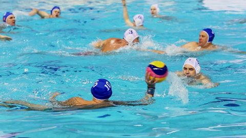 KAZAN, RUSSIA - DEC 09, 2017: Water polo player throws ball and goalkeeper saves gate in match during All Russia Swimming Competition, Alexander Popov Cup. Slow motion