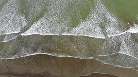 Overhead view of waves breaking on a sandy beach