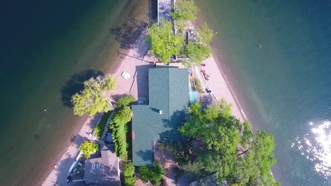 overhead view of house on lake with beaches and dock