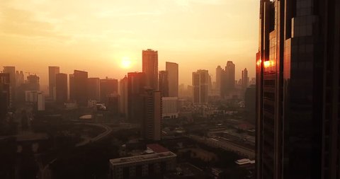 JAKARTA, Indonesia - May 22, 2018: Bird eye view of beautiful sunrise in Jakarta city with modern new buildings on misty morning. Shot in 4k resolution