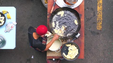 Food vendor cooking popular Malaysian fried banana.Oily food made from banana mix with white flour and serve with kitchup source and known as "goreng pisang". Footage