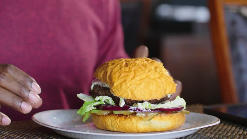 happy fat african american man eating a hamburger.