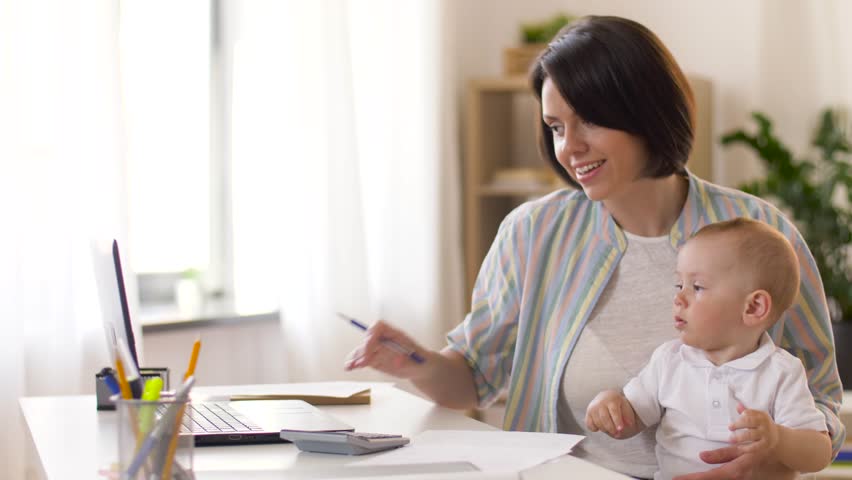 multi-tasking, freelance and motherhood concept - working mother giving pen to baby boy at home office Royalty-Free Stock Footage #1011463217