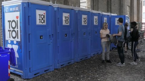 PARMA, ITALY - APRIL, 2018: people are waiting in the next for portable toilets, toi toi