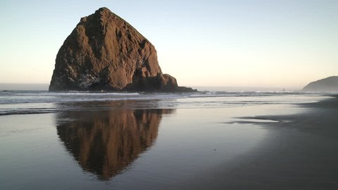 Haystack Rock, Cannon Beach Dawn 4K. UHD. Sunrise at Haystack Rock in Cannon Beach, Oregon as the surf washes up onto the beach. United States.
 Video Stok