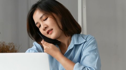 Young asian business owners using computer pc and smart phone at home office.