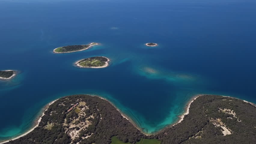 Flight over small desert islands and colorful sea, Brijuni park, Croatia