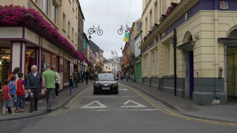 Killarney - May, 2016: People and cars on a street with suspended bikes in Killarney, Ireland