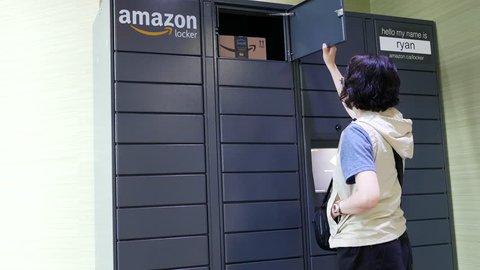 Coquitlam, BC, Canada - May 14, 2018 : Motion of woman taking her parcel at Amazon locker with 4k resolution