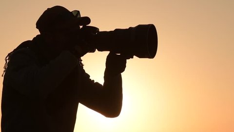 Nature Photographer Taking Pictures at the Sunset. Panoramic Photo. Slow Motion Footage