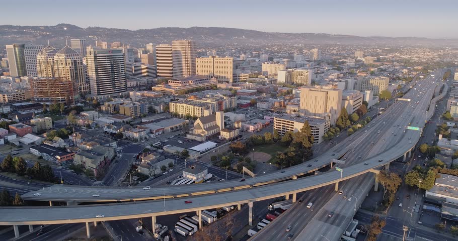 Aerial: Oakland City Skyline and freeway at sunset. California, USA