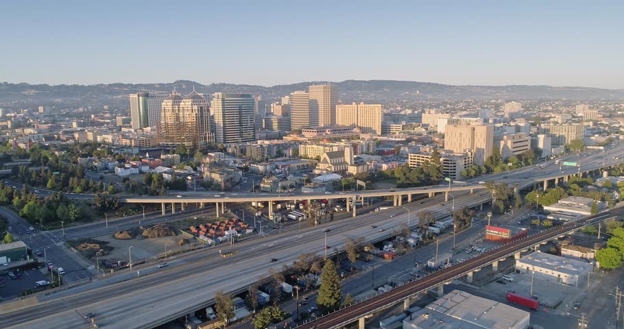 Aerial: Oakland City Skyline and freeway at sunset. California, USA