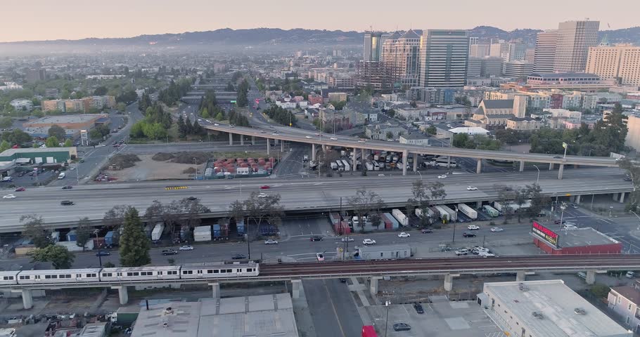 Aerial: Oakland City Skyline and freeway at sunset. California, USA