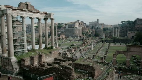 Panning right camera tilt down view of ancient Roman Forum or Foro Romano ruins seen from Capitoline Hill viewpoint in Rome, Italy. 4K UHD at 29.97fps