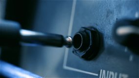 Guitarist Connecting Instrument Cable to Portable Amplifier Outdoors - Close Up - Powered by Shutterstock - Get 15% off with code: PIKWIZARD15