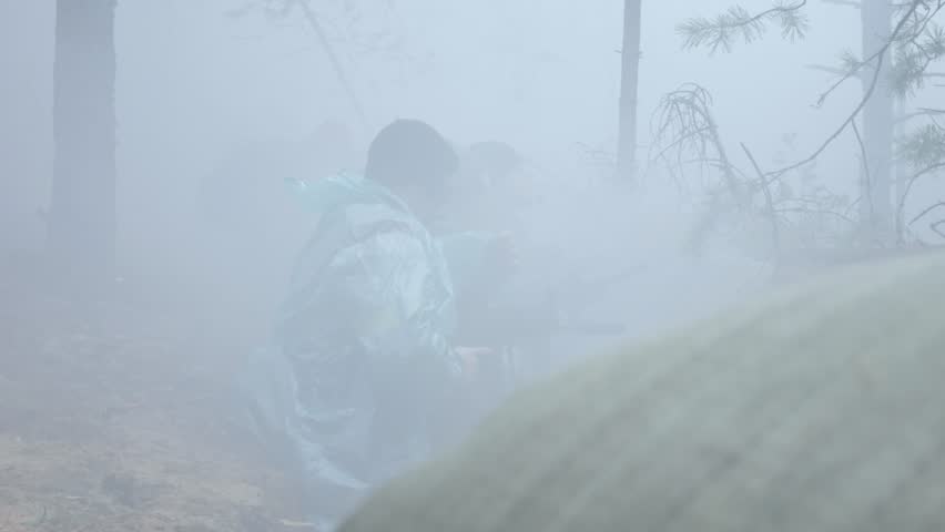 Soldiers in camouflage with combat weapons shoot at the forest shelter, military concept, smoke screen, fog 4k