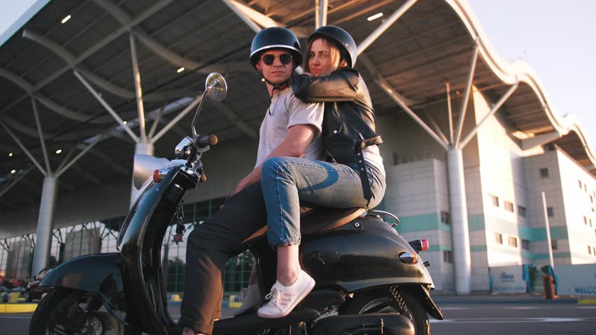 Happy young couple riding vintage scooter on urban background and having some fun, slow motion | Shutterstock HD Video #1011514250