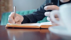 Close up of male hands taking notes in notebook and holding phone. Concept of: business people, phone hand, writing hand, taking notes, digital technologies - Powered by Shutterstock - Get 15% off with code: PIKWIZARD15