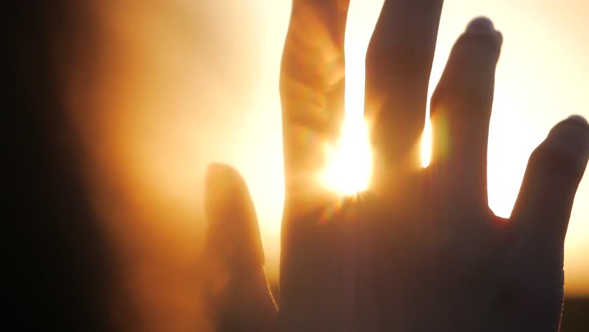 Girl looks at the sun through her hand | Shutterstock HD Video #1011520658