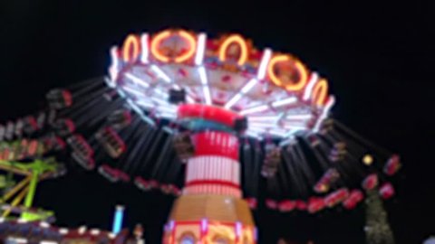 Blurred motion of giant swing ride in amusement park at beautiful night.Fun,Vacation,Travel,Holiday Concept.